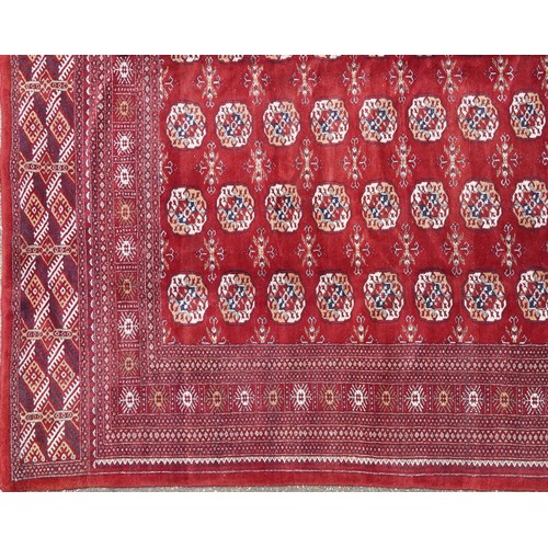  A Pakistan Bokhara carpet, late 20th century, the red field with six central columns of guls within ... 