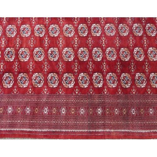  A Pakistan Bokhara carpet, late 20th century, the red field with six central columns of guls within ... 