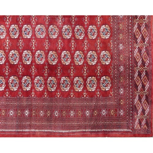  A Pakistan Bokhara carpet, late 20th century, the red field with six central columns of guls within ... 