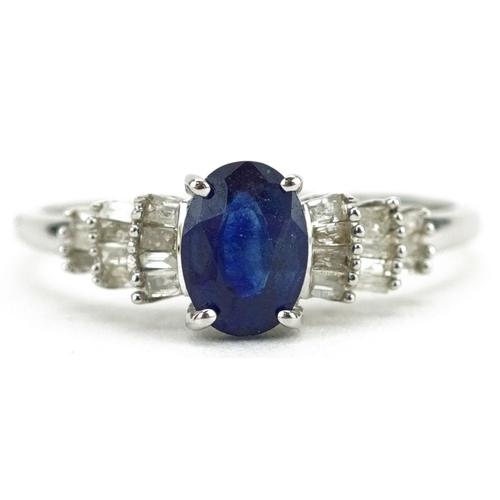 A 9ct white gold sapphire ring with baguette cut diamond stepped shoulders, the sapphire approximately 7.15mm x 5.20mm x 3.20mm deep, size Q, 1.9g.