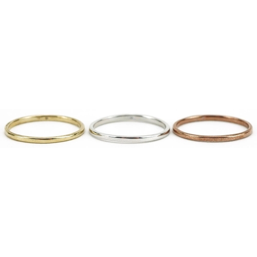 587 - A set of three 9ct three tone gold wedding bands, each set with a solitaire diamond, size M/N, total... 