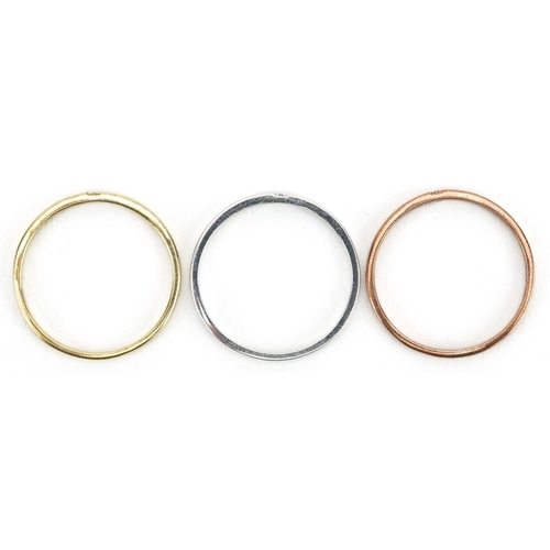 587 - A set of three 9ct three tone gold wedding bands, each set with a solitaire diamond, size M/N, total... 