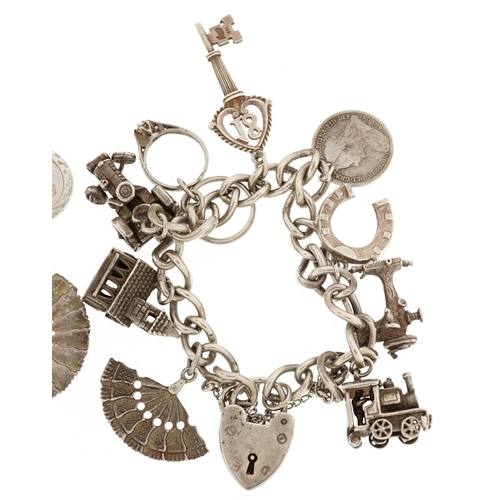 384 - Two silver charm bracelets with a collection of mostly silver charms including a matador, Nefertiti ... 