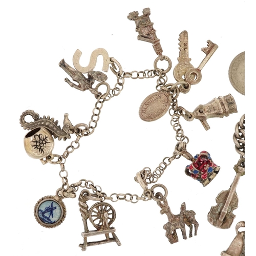 283 - Three silver charm bracelets with a collection of mostly silver charms including spinning wheels, en... 