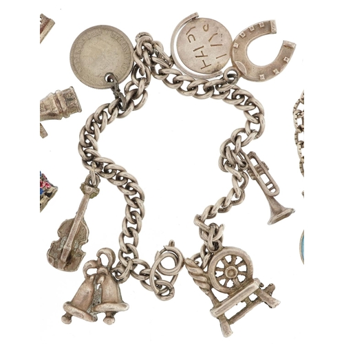 283 - Three silver charm bracelets with a collection of mostly silver charms including spinning wheels, en... 