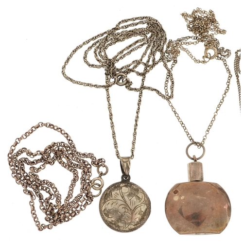 580 - Five silver necklaces, four with pendants, including miniature scent bottle and a locket, total 32.0... 