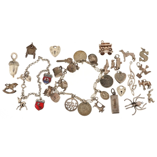 598 - A silver charm bracelet and a large collection of mostly silver charms including Gypsy carriage with... 