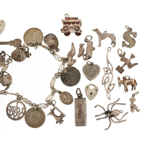 598 - A silver charm bracelet and a large collection of mostly silver charms including Gypsy carriage with... 