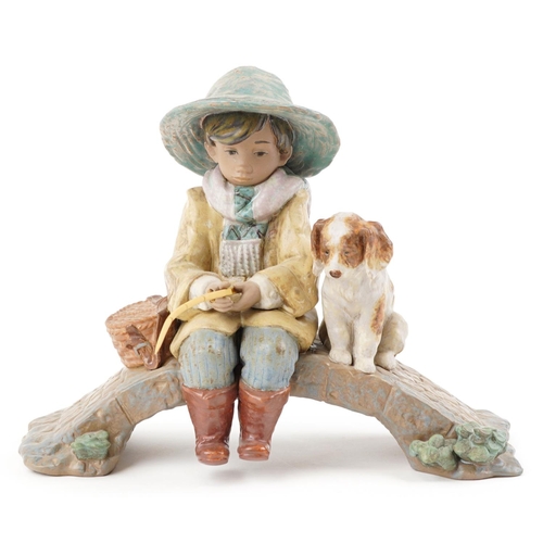  A Lladro Gres study of a young boy with fishing rod and puppy - The Old Fishing Hole, 30cm wide.