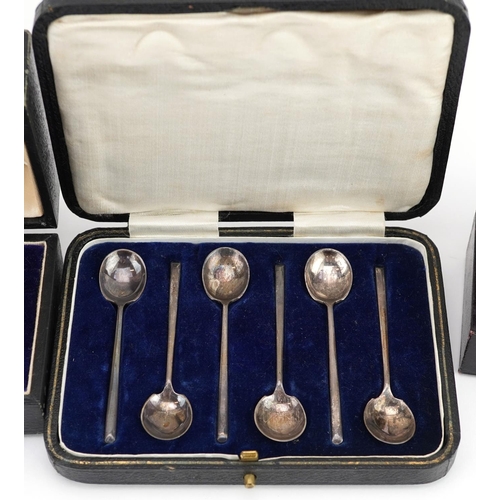 697 - Edwardian and later silver items comprising three napkin rings and a set of six coffee bean spoons, ... 