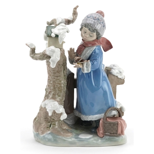 724 - A Lladro figure of a child holding a bird beside a tree - Winter Girl, numbered 5287, 26cm high, wit... 