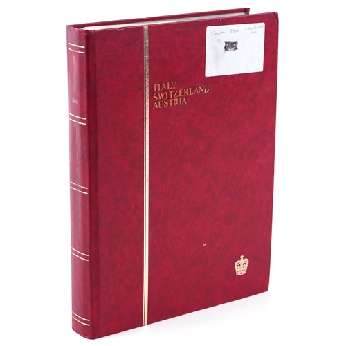 1519 - A red stamp album with 19th century and later stamps of Italy, Switzerland and Austria.