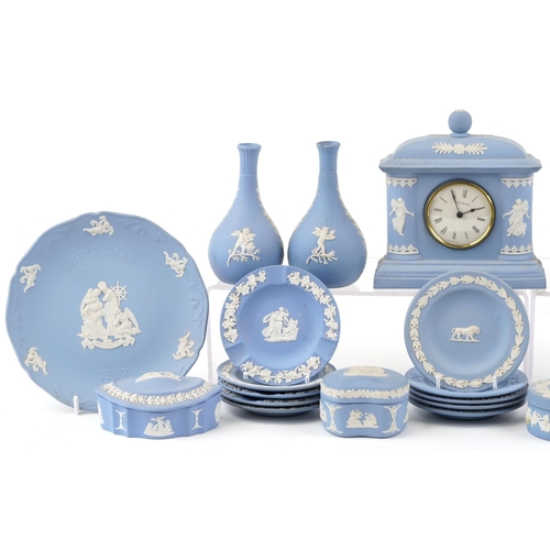 424 - A small collection of blue Wedgwood Jasperware to include trinket boxes, a mantle clock and vases.