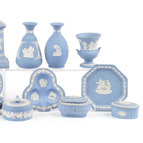 424 - A small collection of blue Wedgwood Jasperware to include trinket boxes, a mantle clock and vases.