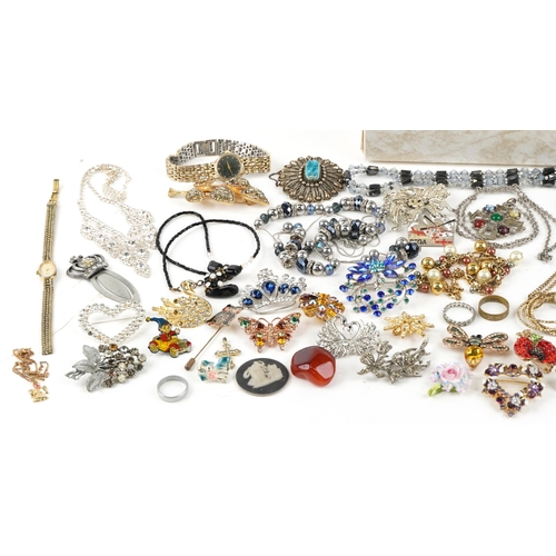 2577 - A small mixed group of costume jewellery including brooches, necklaces and pendants within a cream l... 