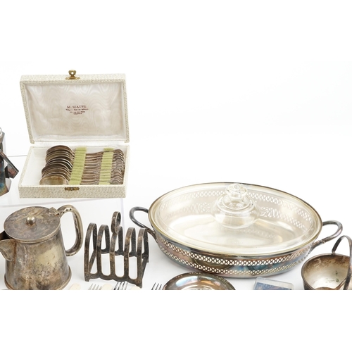 1380 - A collection of plated items to include a three piece tea set, spill vase, toast rack and various cu... 