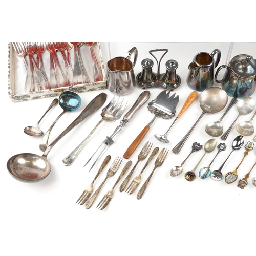 1380 - A collection of plated items to include a three piece tea set, spill vase, toast rack and various cu... 