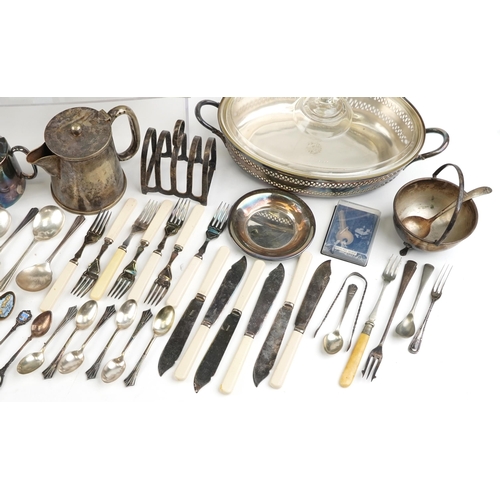 1380 - A collection of plated items to include a three piece tea set, spill vase, toast rack and various cu... 