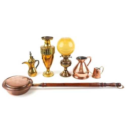 1243 - A small group of brass and copper items including a copper warming pan, an oil lamp, two jugs and a ... 