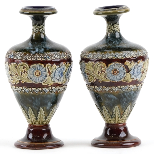 186 - A pair of Doulton Lambeth stoneware pottery vases decorated with flowers, bearing impressed marks to... 