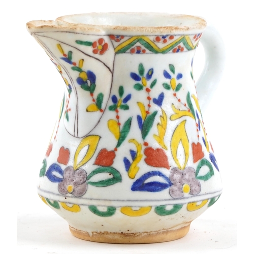 173 - A 19th century Turkish Ottoman Kütahya jug hand painted with stylized flowers and motifs, 12cm high.