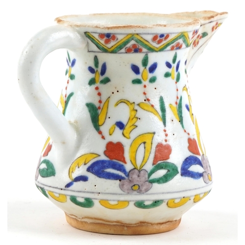 173 - A 19th century Turkish Ottoman Kütahya jug hand painted with stylized flowers and motifs, 12cm high.