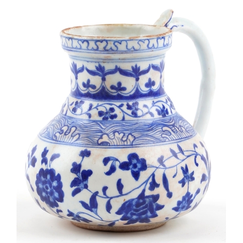 169 - A Turkish Ottoman Iznik jug hand painted with stylized flowers and motifs, 17cm high.