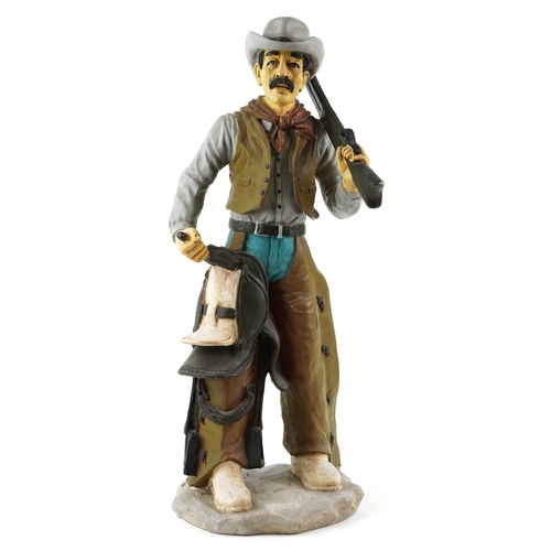 1308 - A large decorative model of a cowboy holding a gun, 75cm high.