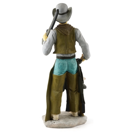 1308 - A large decorative model of a cowboy holding a gun, 75cm high.