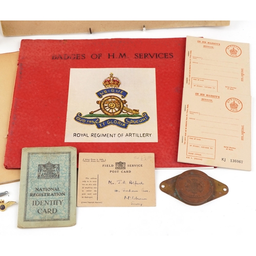 725 - A small group of militaria to include a white painted tin first aid box, a Badges of HM Services boo... 