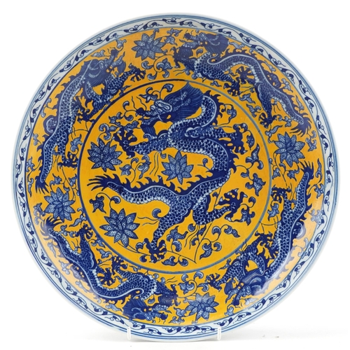 325 - A Chinese porcelain charger hand painted with a continuous band of dragons, character marks to the b... 