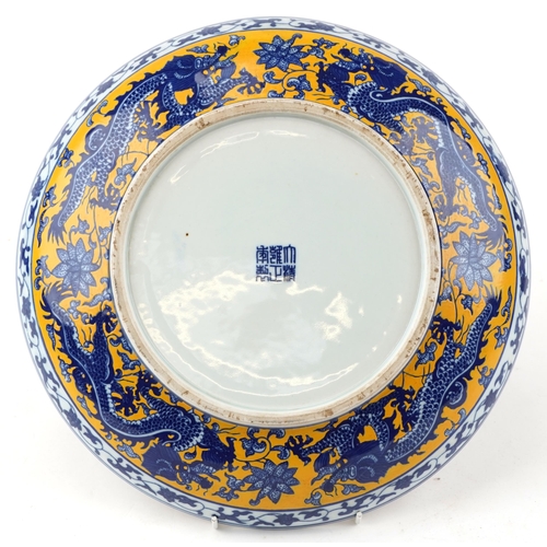 325 - A Chinese porcelain charger hand painted with a continuous band of dragons, character marks to the b... 