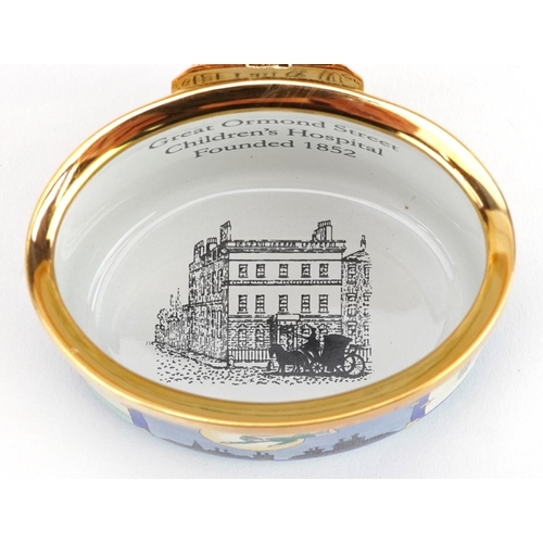 402 - A Halcyon Days enamelled Peter Pan trinket box and a Buckingham Palace enamelled clock, each with fi... 