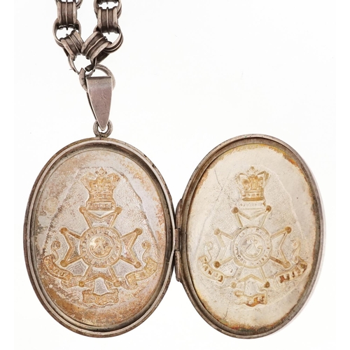 760 - A military interest King's Rifles Peninsula white metal locket on a white metal necklace, the locket... 