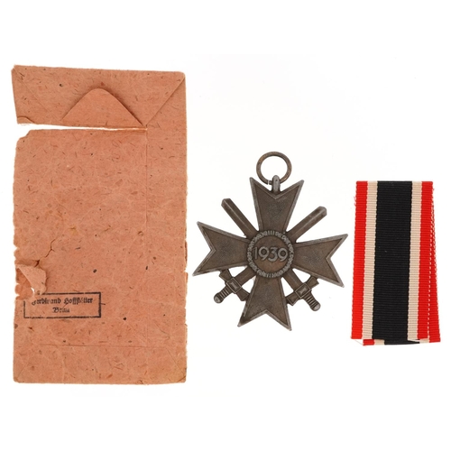 759 - A German military World War II Merit Cross with paper packet.