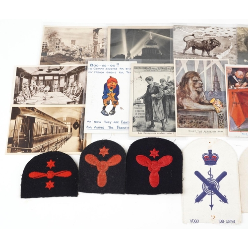 708 - A collection of militaria including comical postcards and aviation cloth patches.