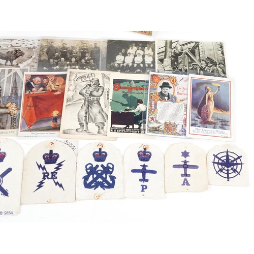 708 - A collection of militaria including comical postcards and aviation cloth patches.