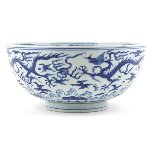  A large Chinese blue and white porcelain footed bowl hand painted with dragons chasing flaming pearl... 