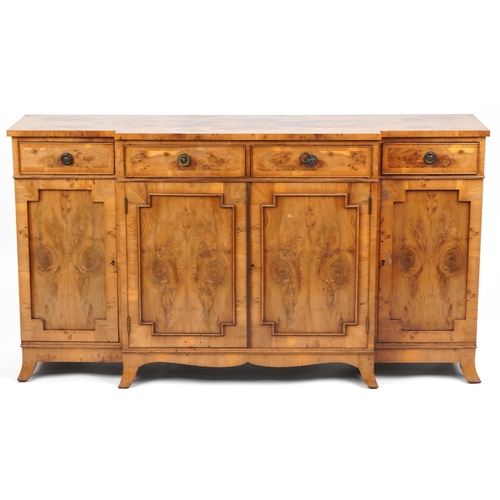 1030 - A late 20th century George III style breakfront walnut sideboard fitted with four frieze drawers abo... 