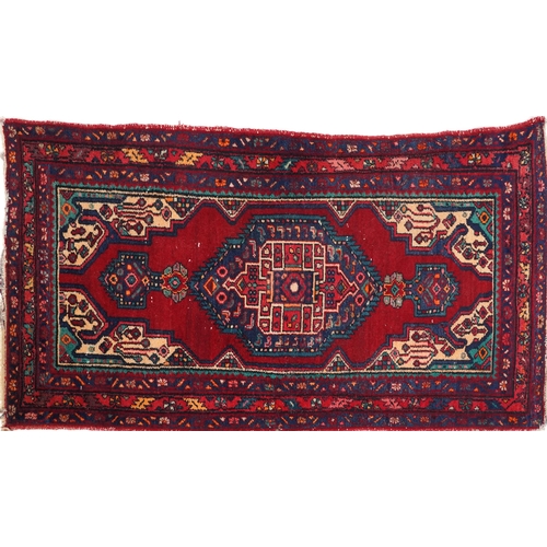 1017 - A Turkish rug, late 20th century, the red field with a central stylized medallion within a complemen... 