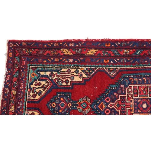 1017 - A Turkish rug, late 20th century, the red field with a central stylized medallion within a complemen... 