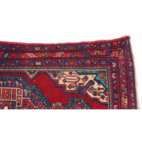 1017 - A Turkish rug, late 20th century, the red field with a central stylized medallion within a complemen... 