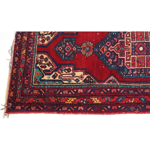 1017 - A Turkish rug, late 20th century, the red field with a central stylized medallion within a complemen... 