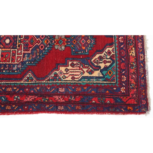 1017 - A Turkish rug, late 20th century, the red field with a central stylized medallion within a complemen... 