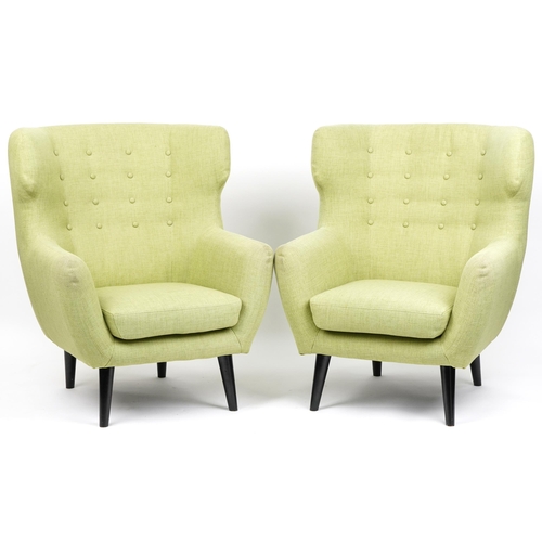 1013 - A pair of modern button back armchairs upholstered in green fabric raised on ebonised tapering legs,... 