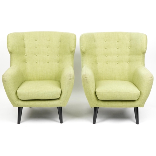 1013 - A pair of modern button back armchairs upholstered in green fabric raised on ebonised tapering legs,... 