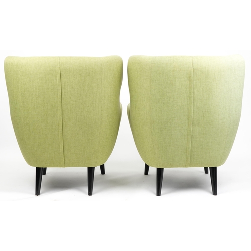 1013 - A pair of modern button back armchairs upholstered in green fabric raised on ebonised tapering legs,... 