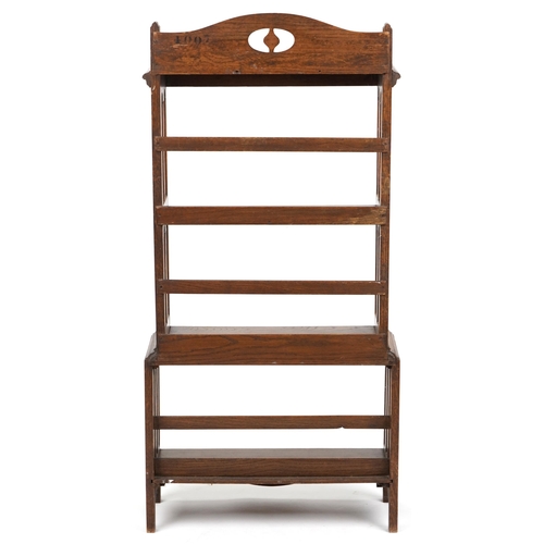 1024 - An early 20th century Arts & Crafts oak four tier open bookcase with pierced decoration, 129cm H x 6... 