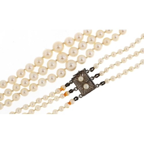 158 - A vintage three row graduated cultured pearl necklace with silver clasp housed in a Mikimoto leather... 