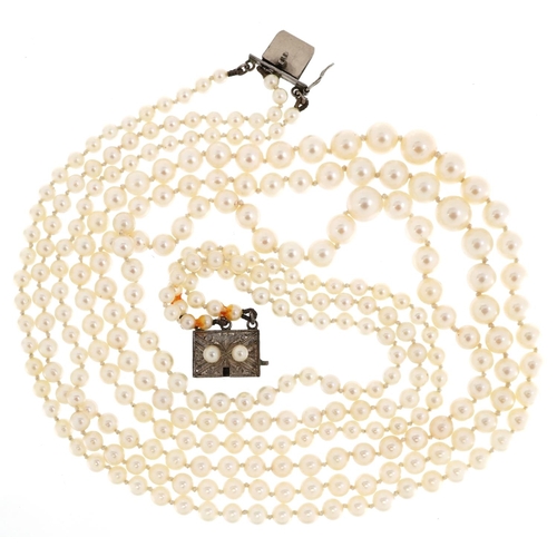 158 - A vintage three row graduated cultured pearl necklace with silver clasp housed in a Mikimoto leather... 